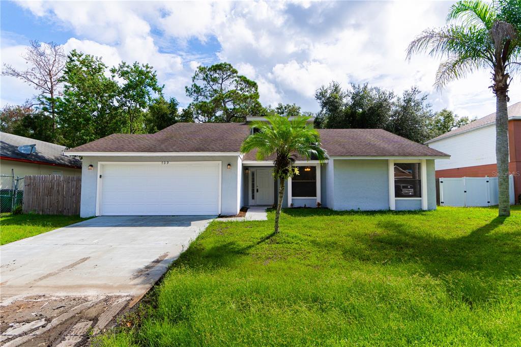 a front view of a house with a yard and garage