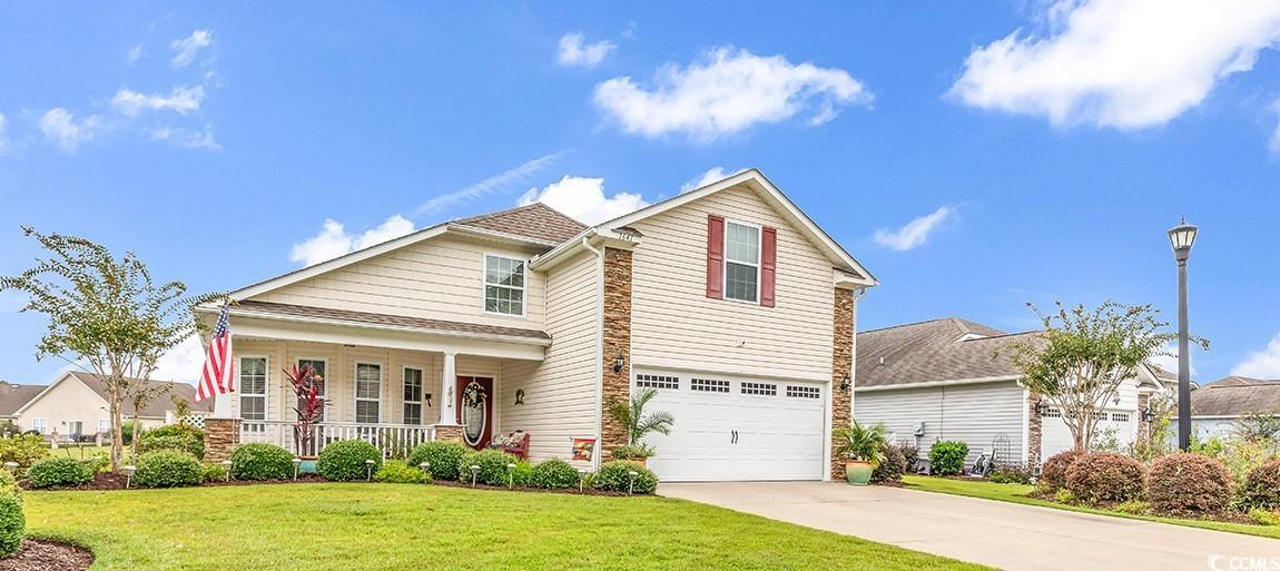 View of front of home featuring covered porch, a f