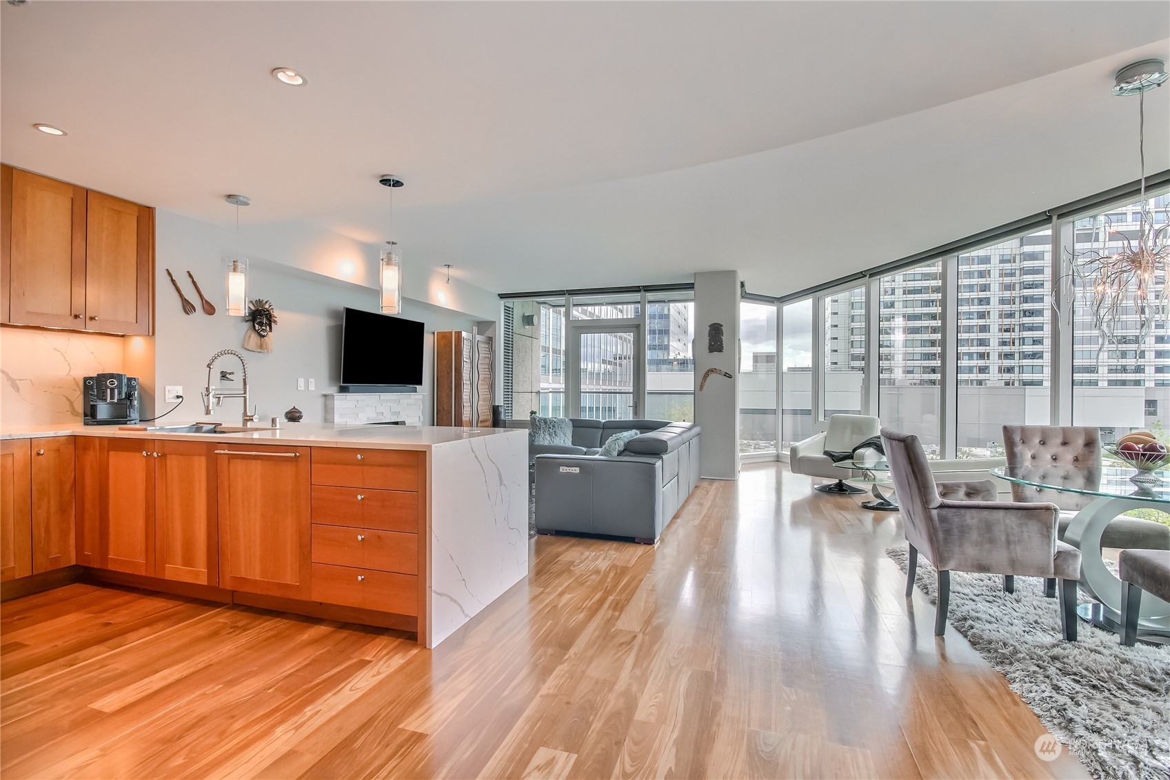 a large living room with stainless steel appliances granite countertop a couch wooden floor and a view of living room