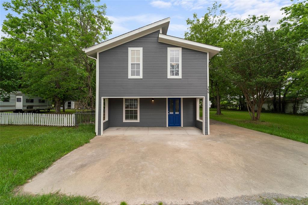 a front view of a house with yard and green space