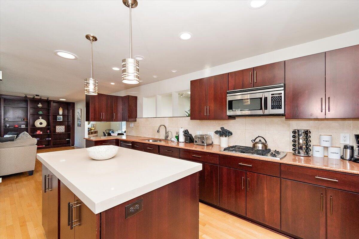 a kitchen with sink a microwave and cabinets