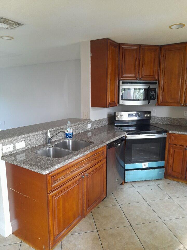 a kitchen with stainless steel appliances granite countertop a stove a sink and a microwave