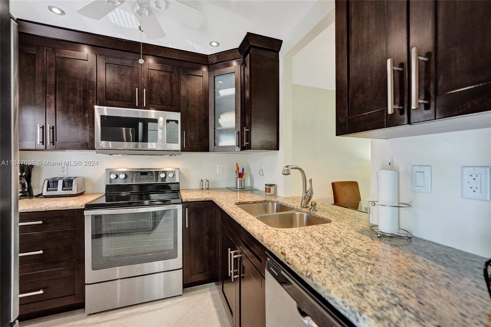 a kitchen with stainless steel appliances granite countertop a sink and stove top oven