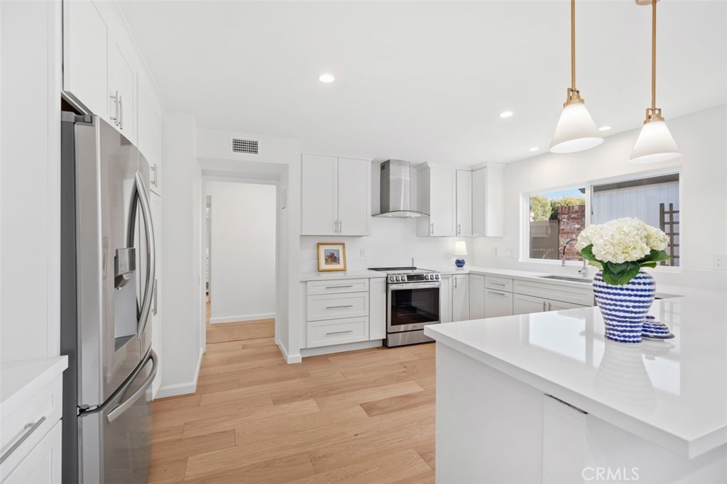 a kitchen with stainless steel appliances kitchen island granite countertop a refrigerator and a stove top oven