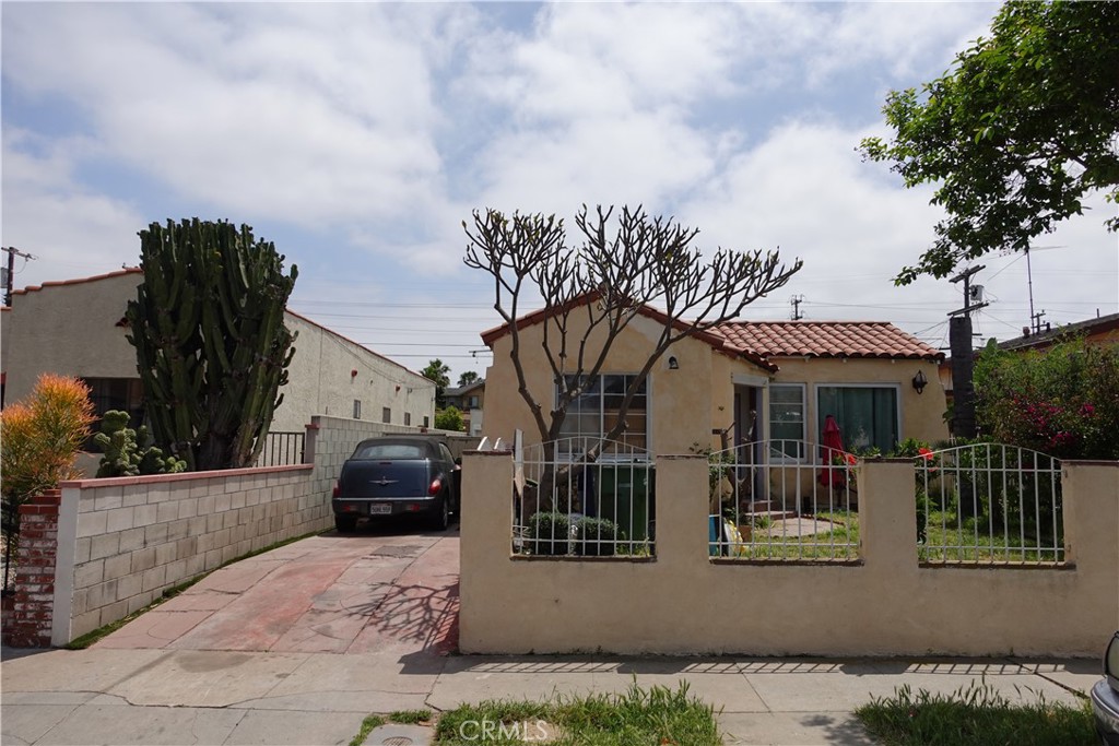 a front view of a house with a garden and balcony