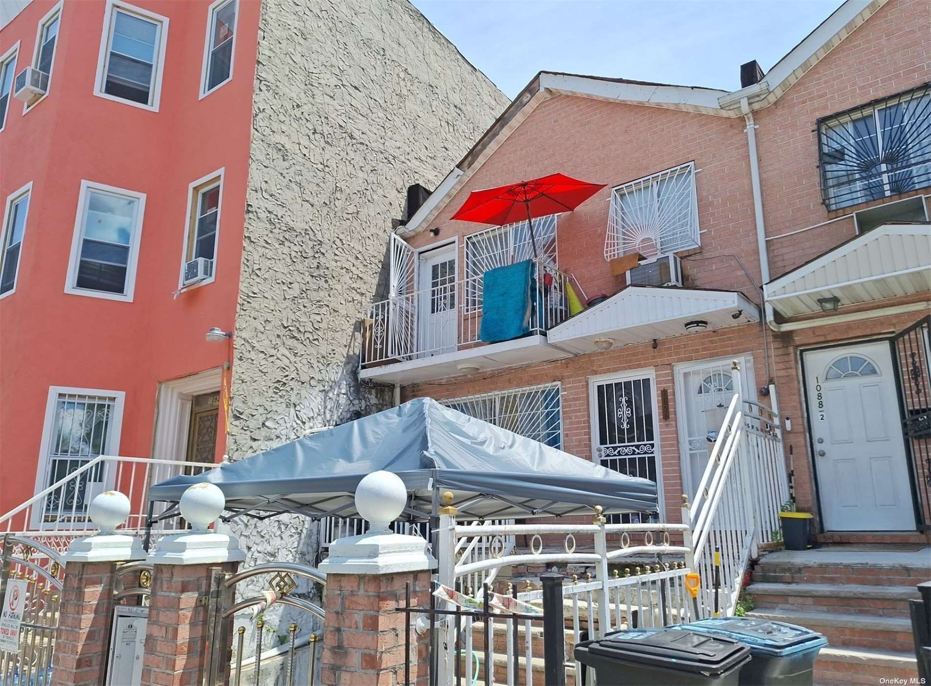 a view of a patio with couches table and chairs under an umbrella