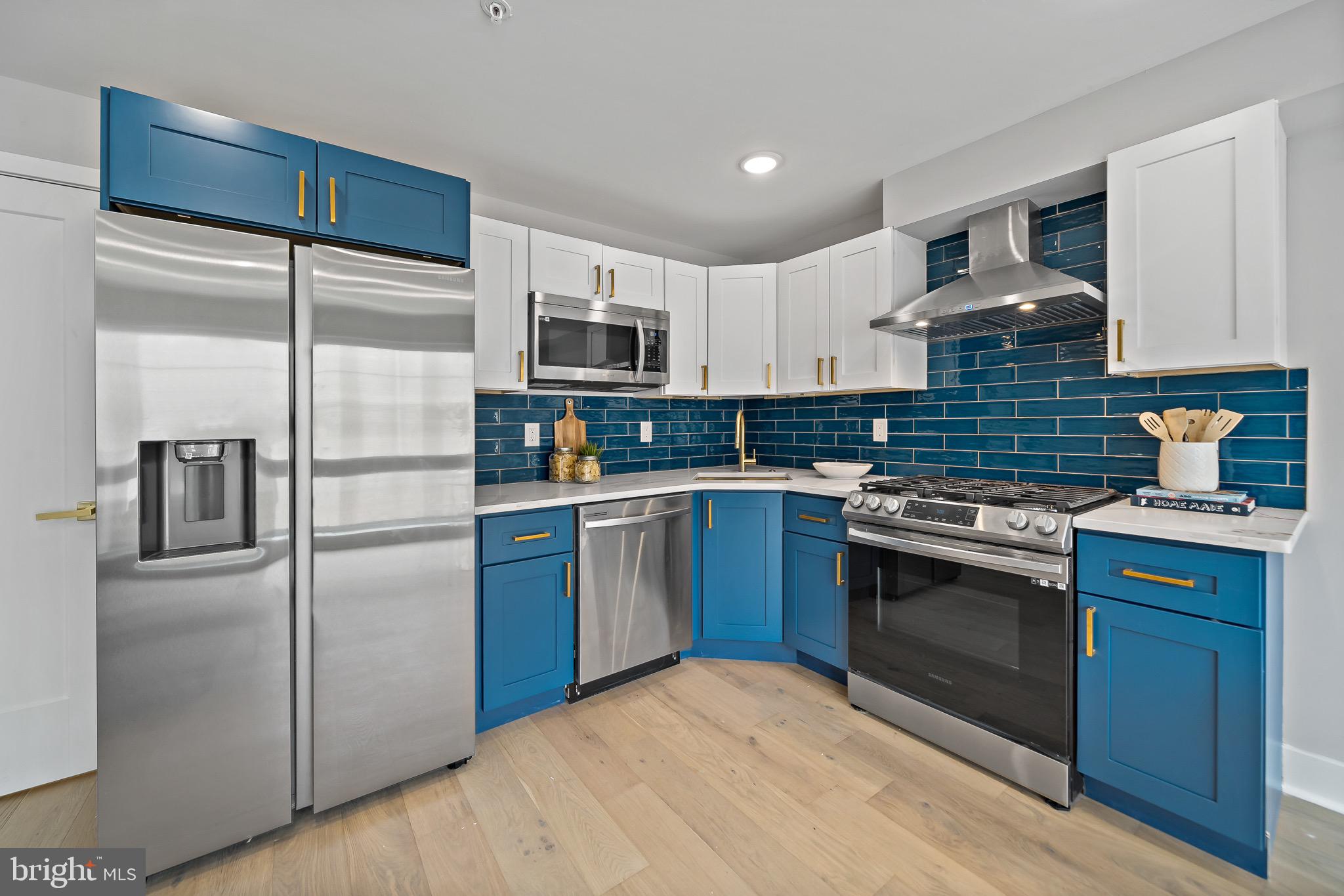 a kitchen with kitchen island a counter top space stainless steel appliances and cabinets