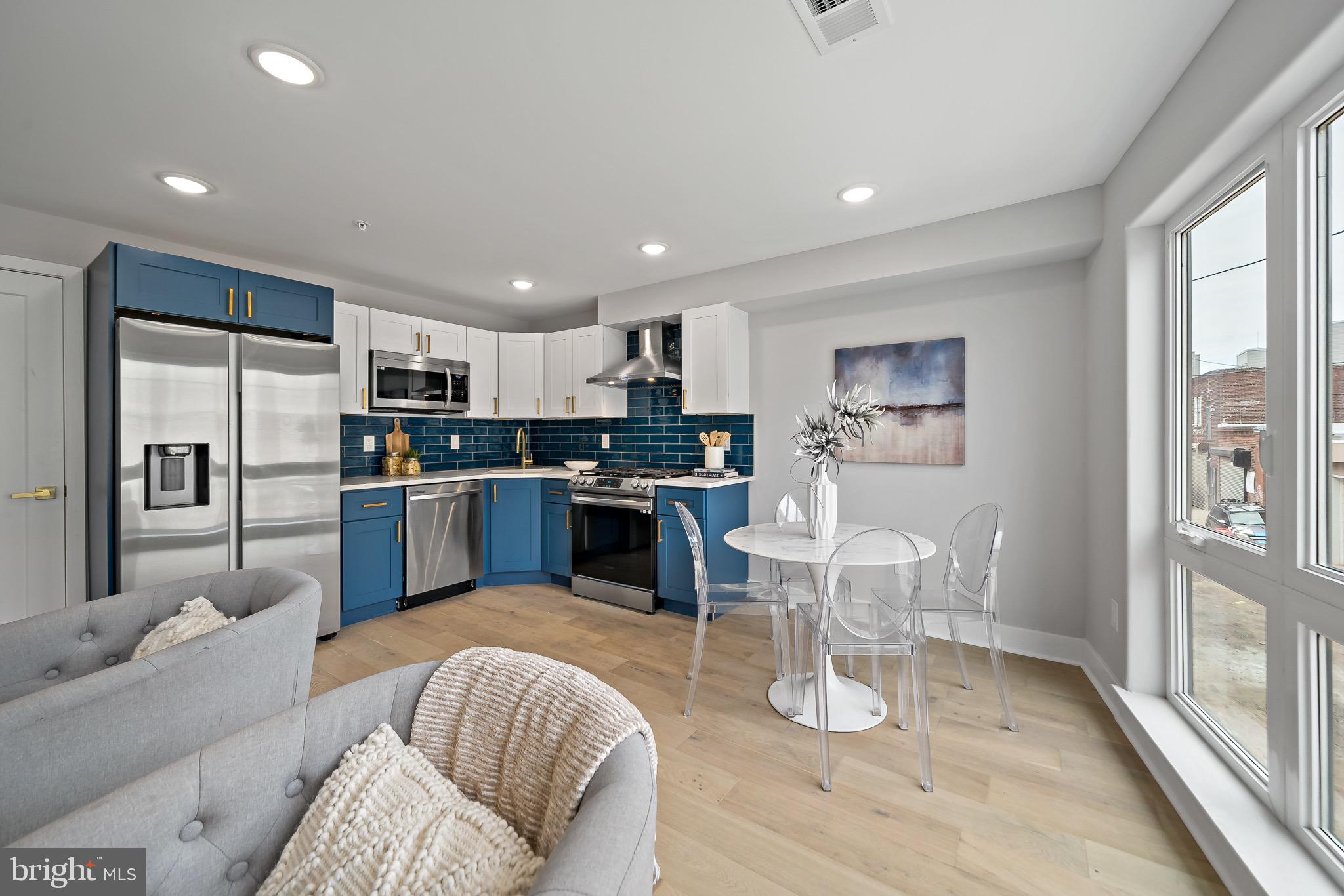 a living room with stainless steel appliances furniture and a large window