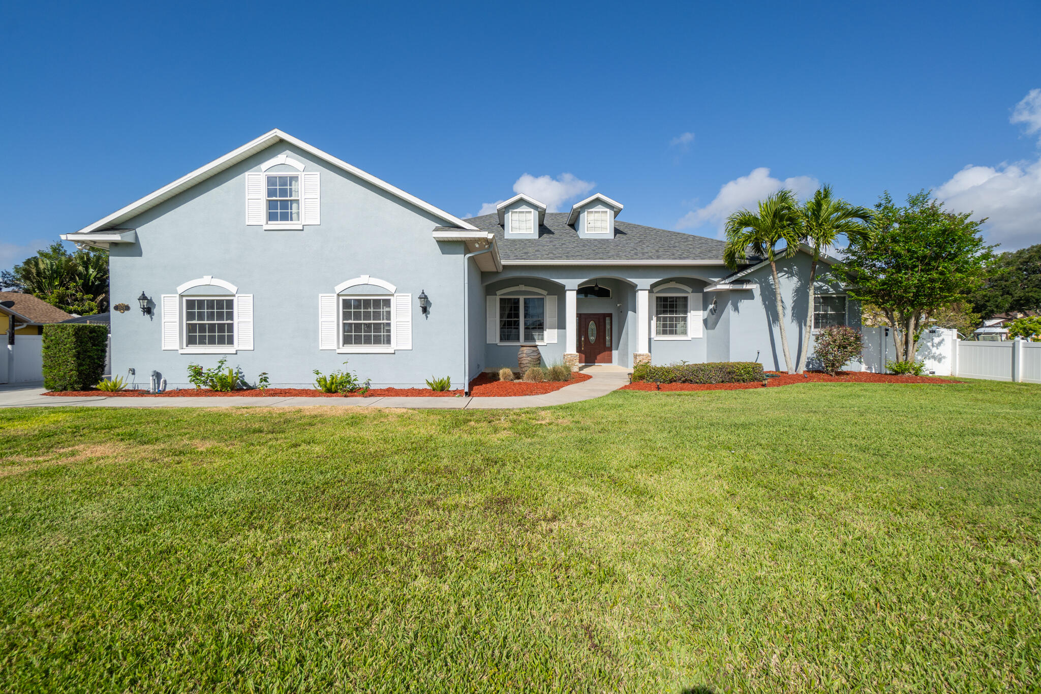 a front view of a house with a garden and yard