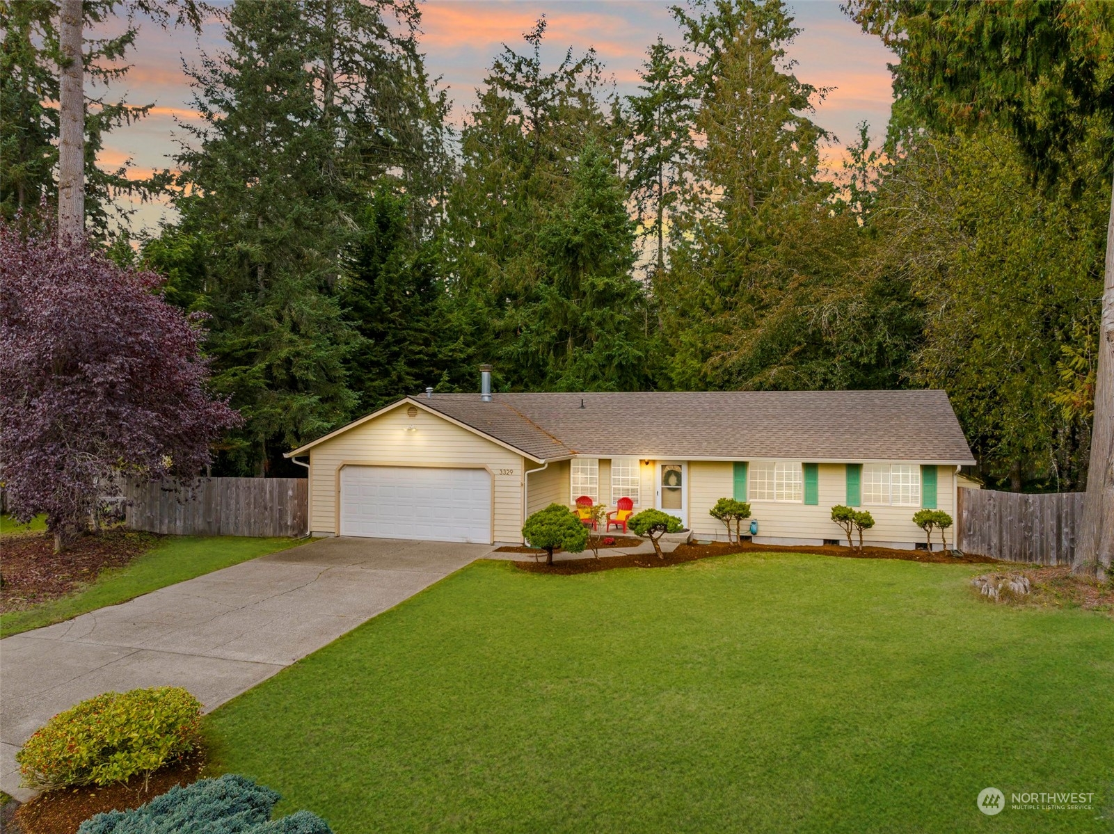 a front view of a house with a garden and trees