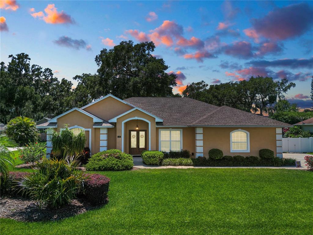 a front view of a house with a yard and green space