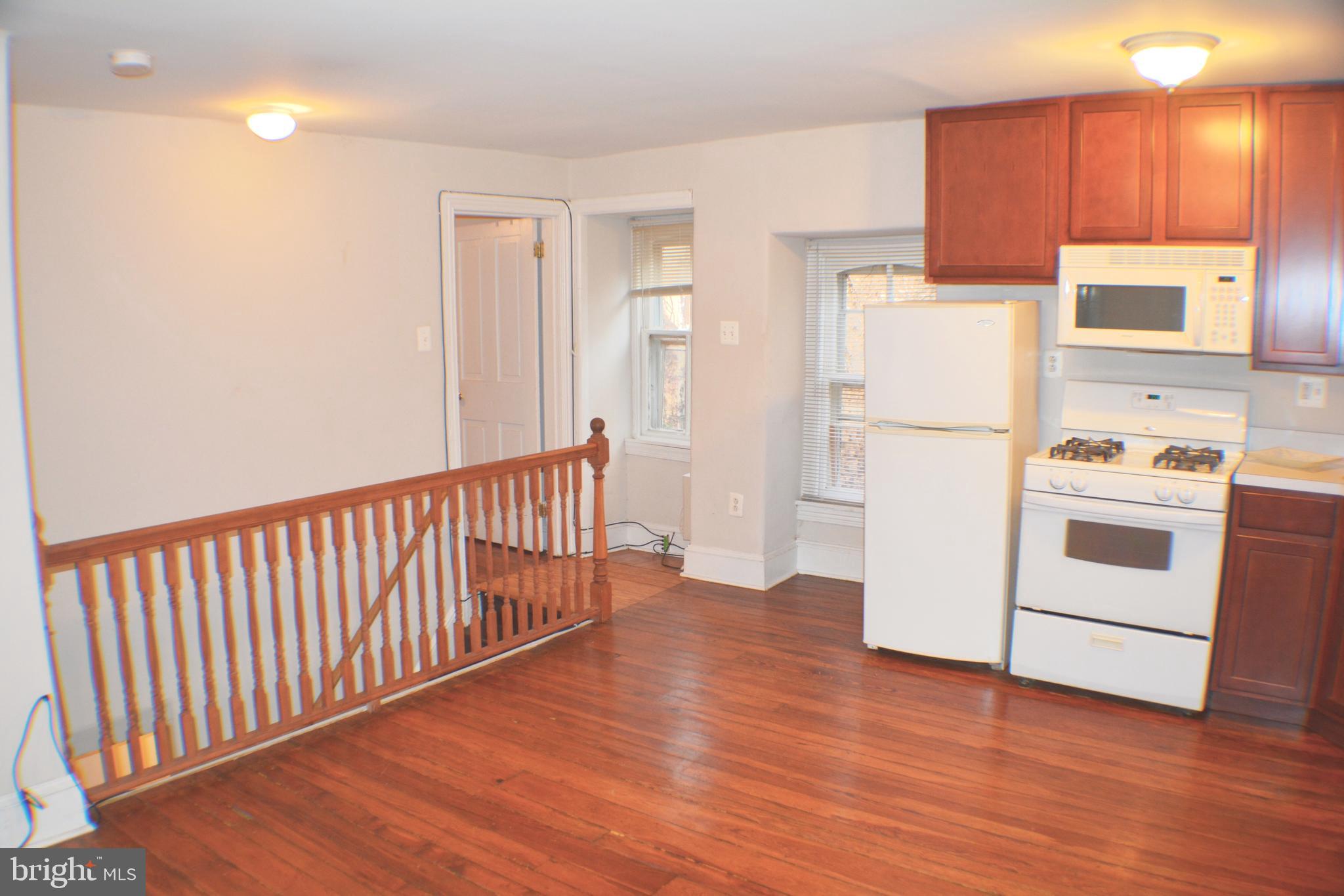 a view of a kitchen with wooden floor and electronic appliances