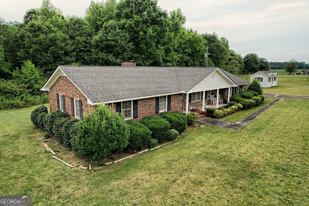 a aerial view of a house with yard and green space