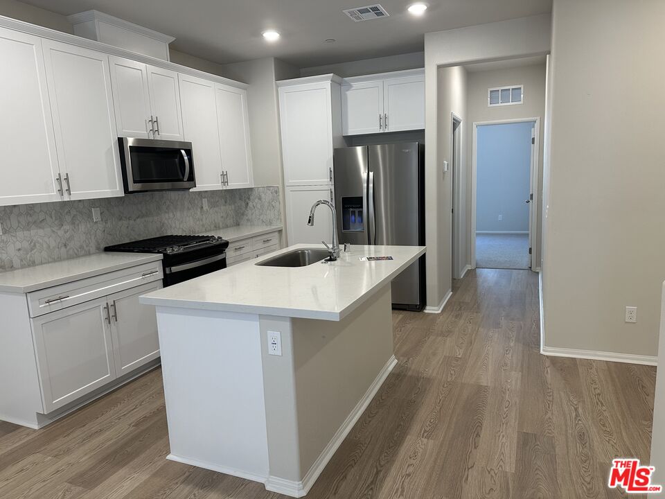 a kitchen that has a sink and a stove in it