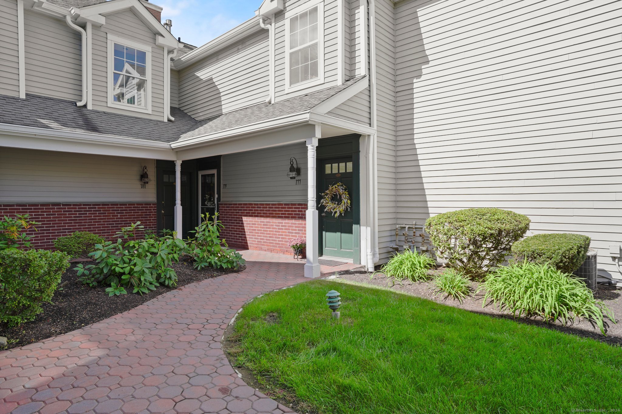 a front view of a house with a garden and plants