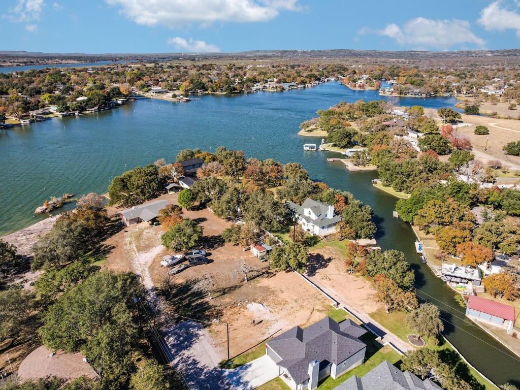 an aerial view of ocean and residential houses with outdoor space