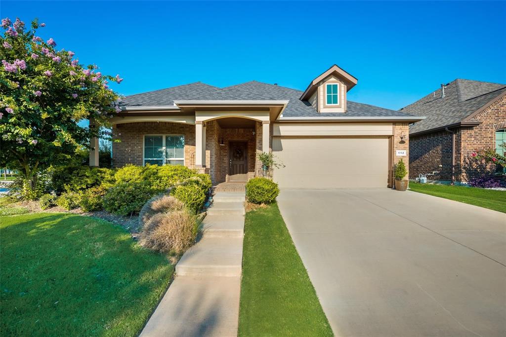 a front view of a house with a yard and potted plants