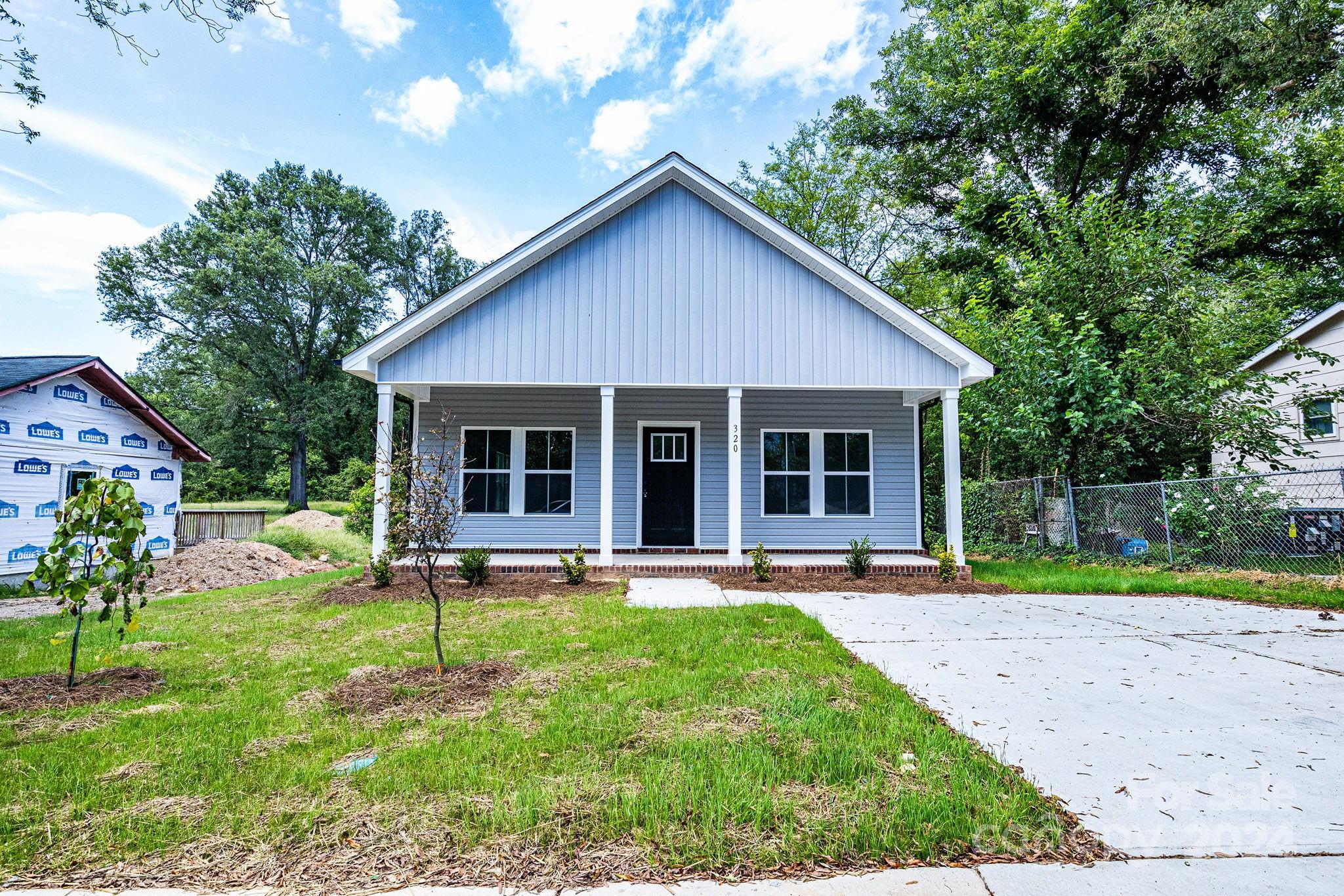 a view of a house with a yard and sitting area