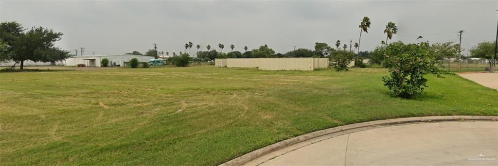 a view of a field with an trees in the background