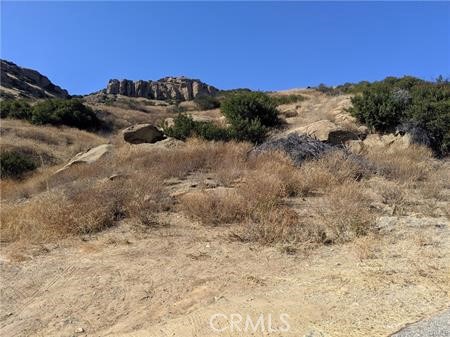 a view of a dry yard with mountains in the background