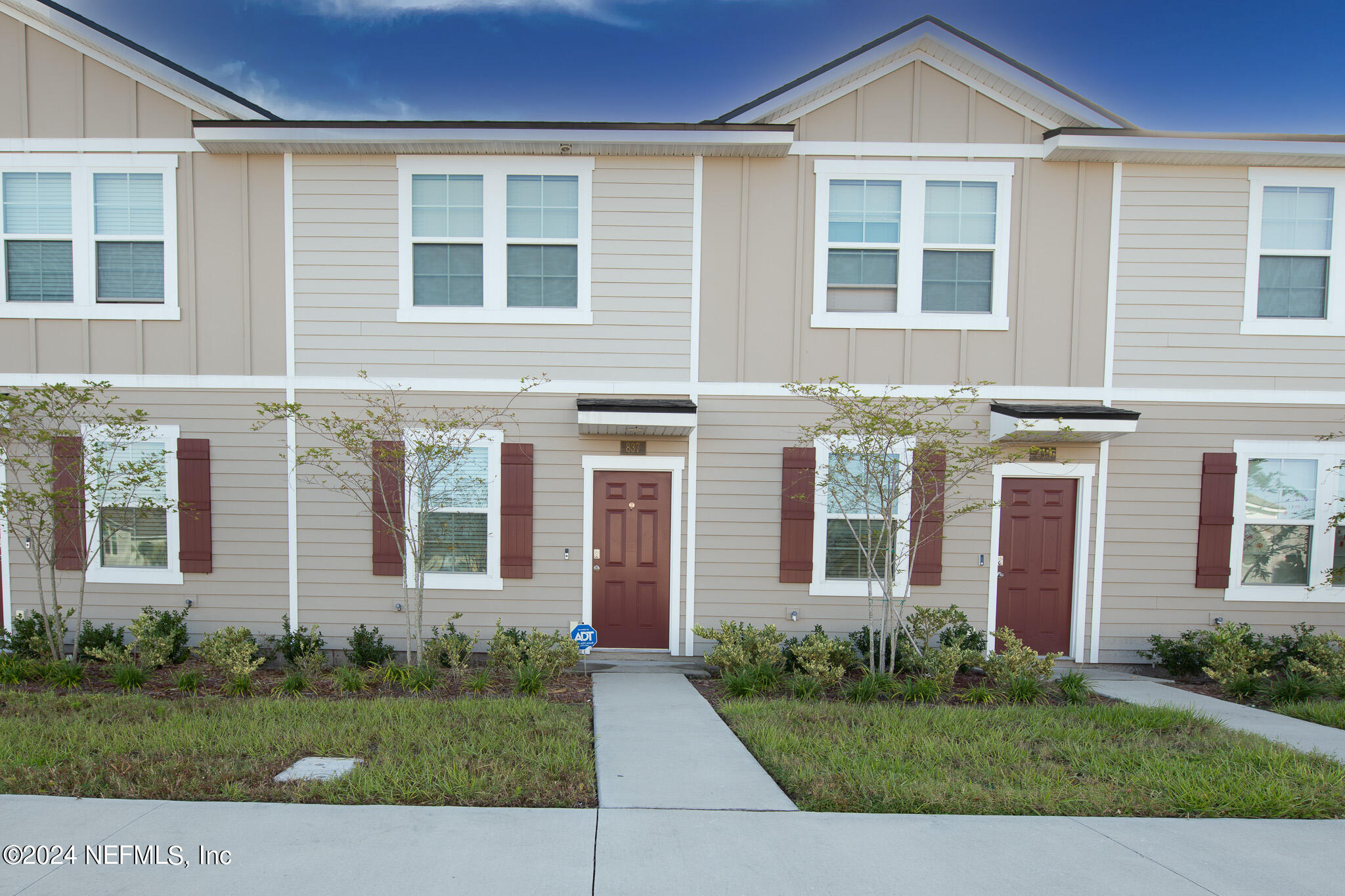 front view of a brick house and a yard