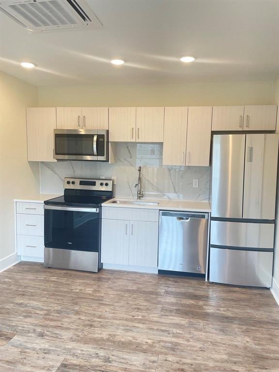 a kitchen with stainless steel appliances a refrigerator sink and microwave