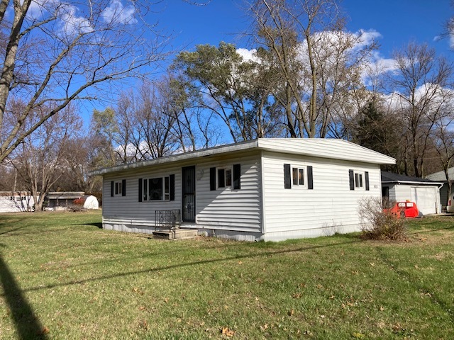 a front view of house with yard and trees around