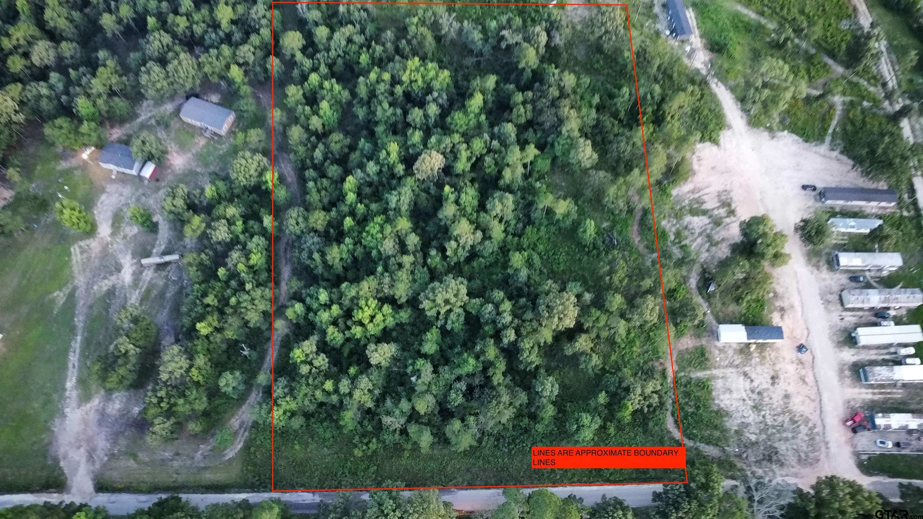 an aerial view of residential houses with outdoor space and trees