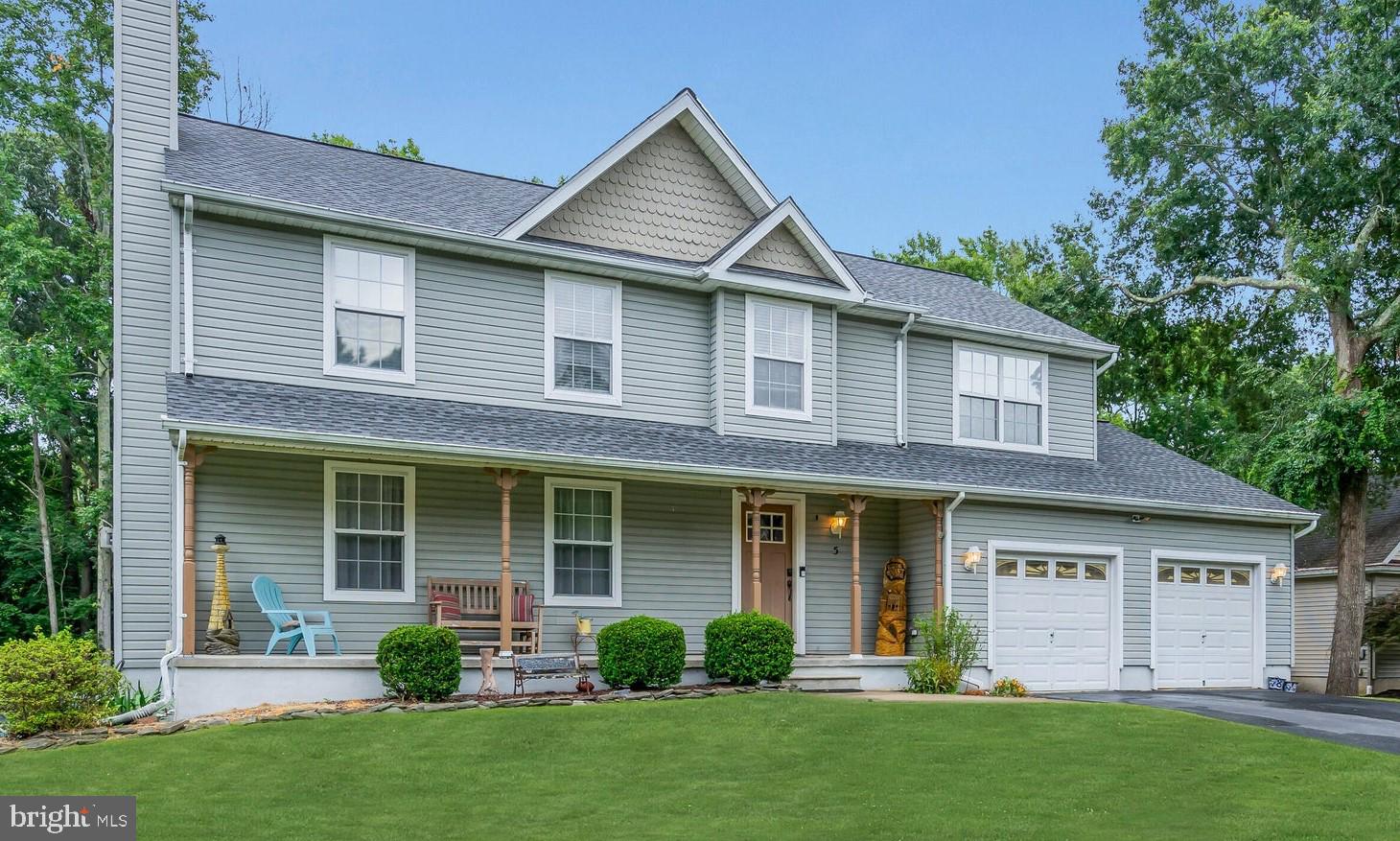 a front view of a house with a yard and green space