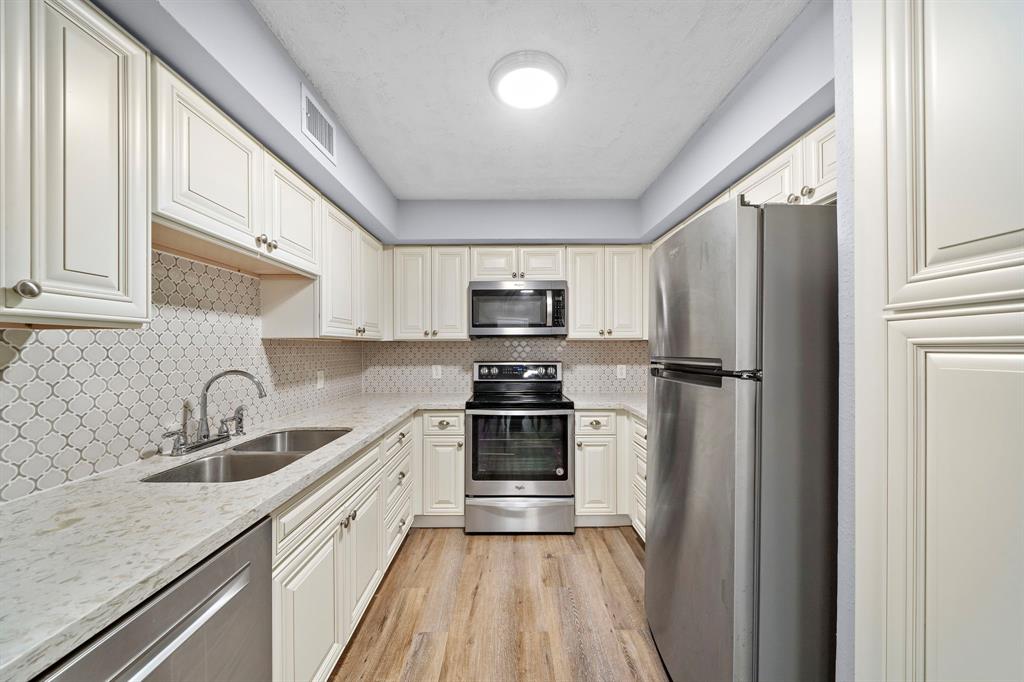 a kitchen with a sink stainless steel appliances and cabinets