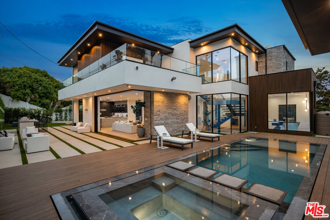 a view of a house with pool and chairs and floor to ceiling window