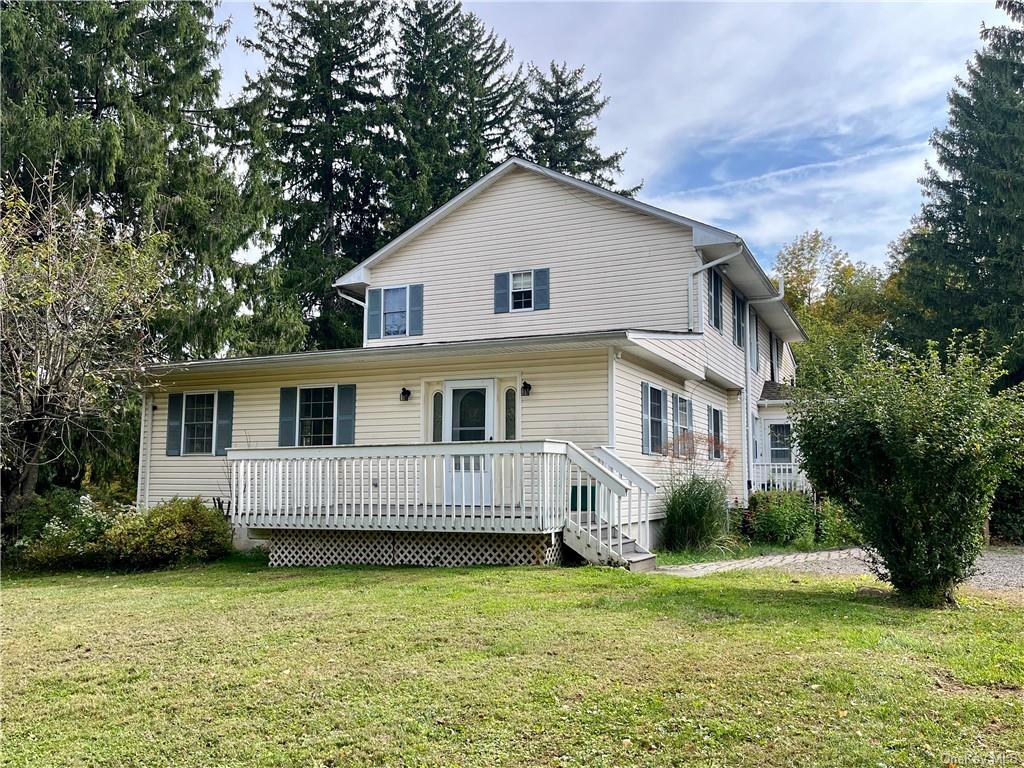 Back of property with a deck and a lawn