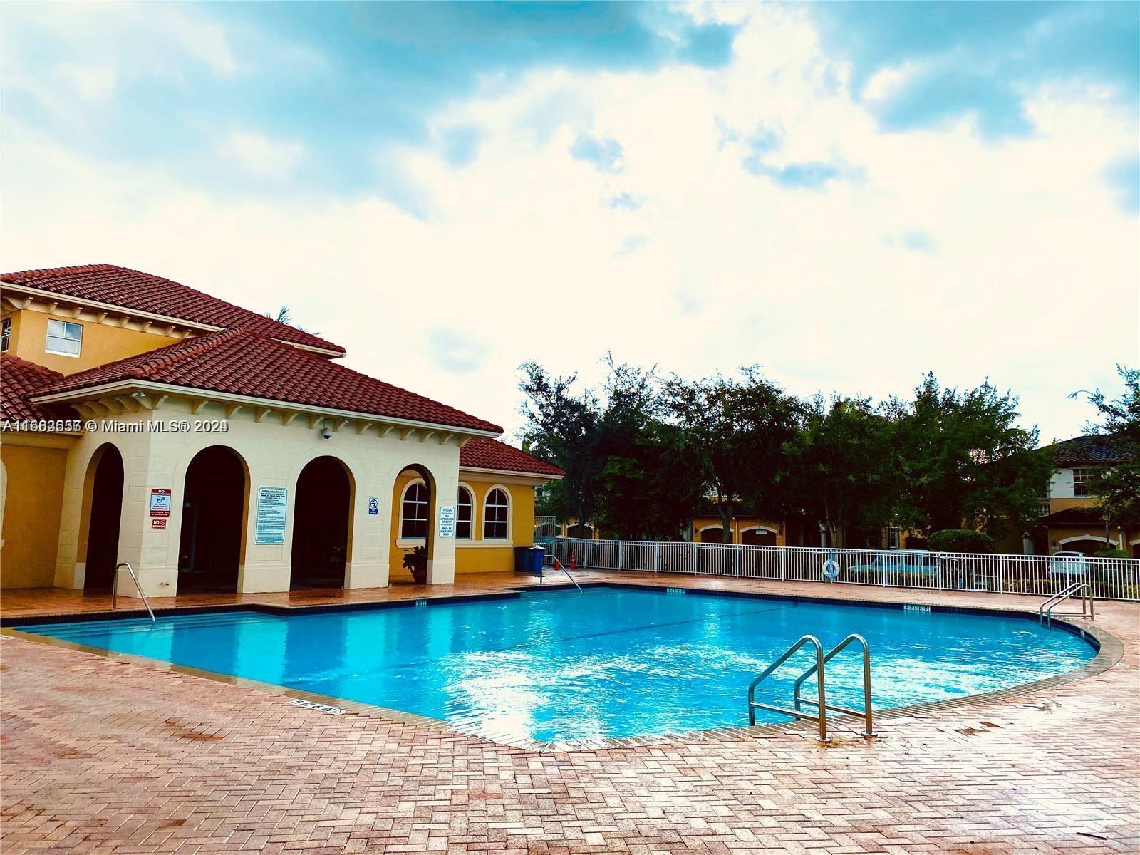 a view of a house with pool and sitting area