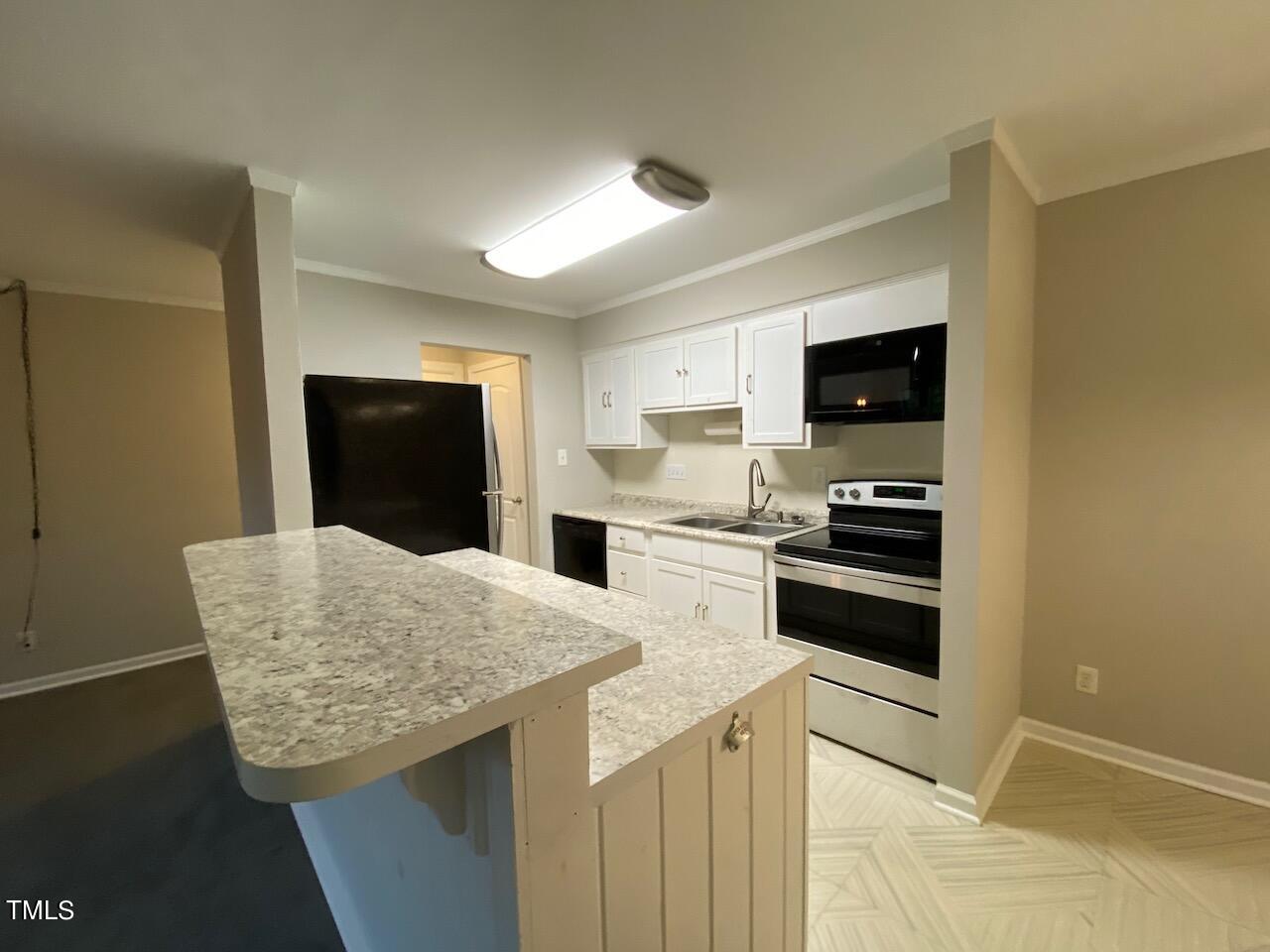 a kitchen with granite countertop a refrigerator stove and microwave