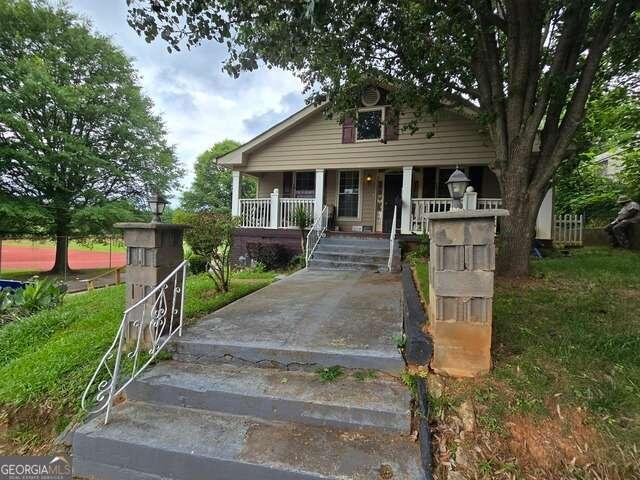 a front view of house with a yard and green space