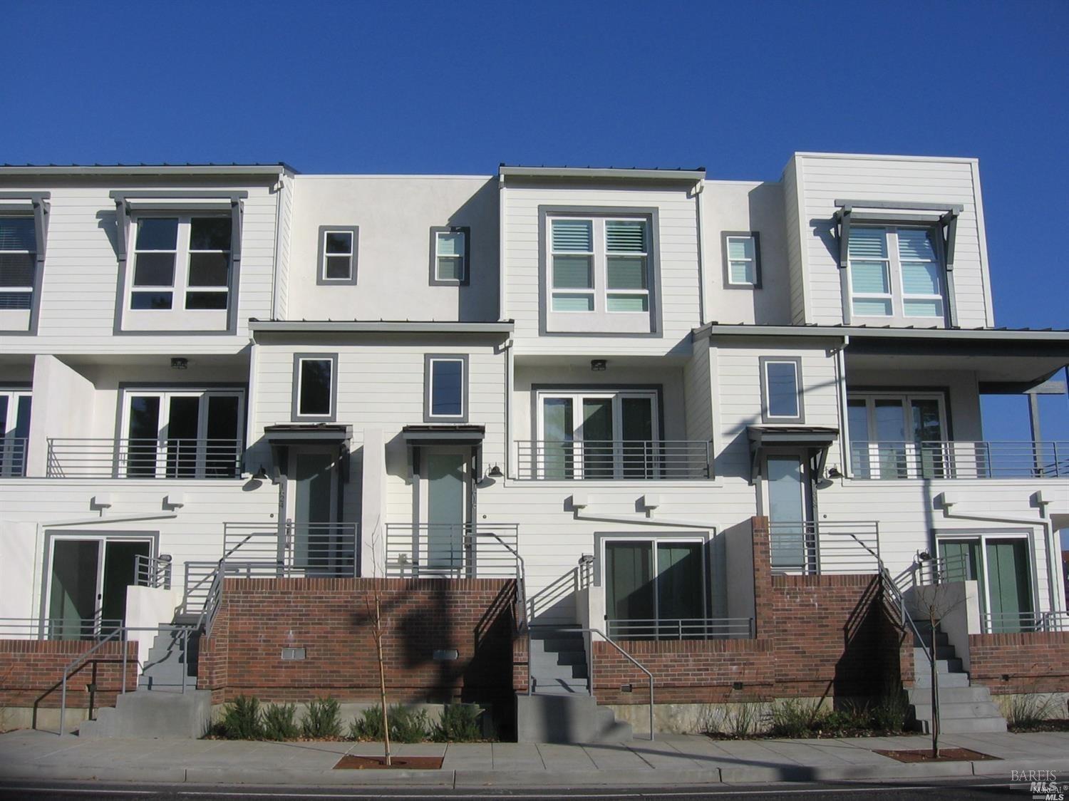 a front view of a residential apartment building with a yard