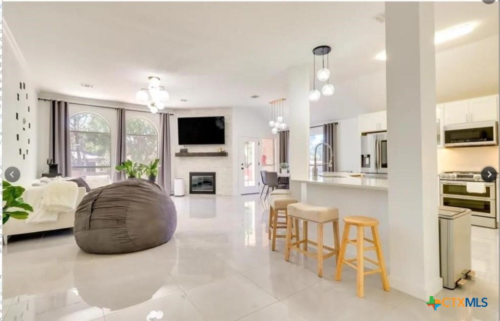 a living room with furniture a fireplace and a flat screen tv