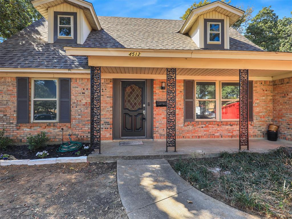 front view of a brick house with a yard