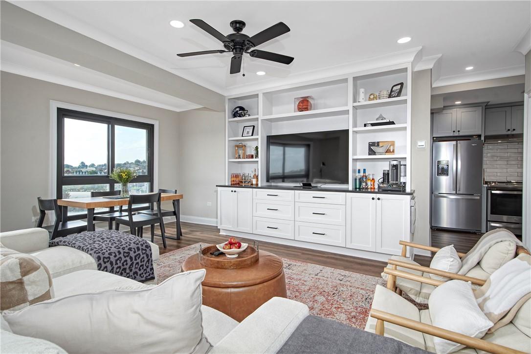 Living room featuring ceiling fan, ornamental molding, and dark wood-type flooring