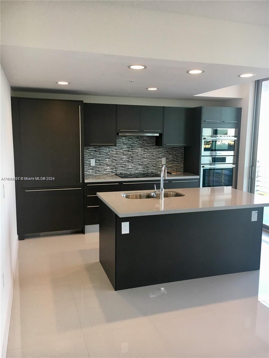 a view of kitchen with stainless steel appliances wooden cabinets and sink