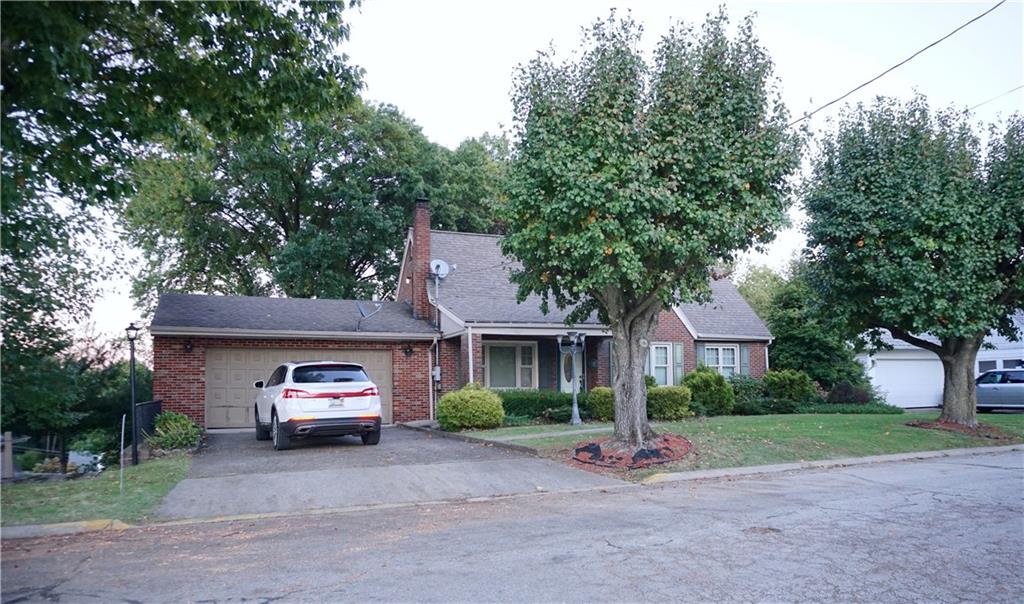 a front view of a house with a garden and trees