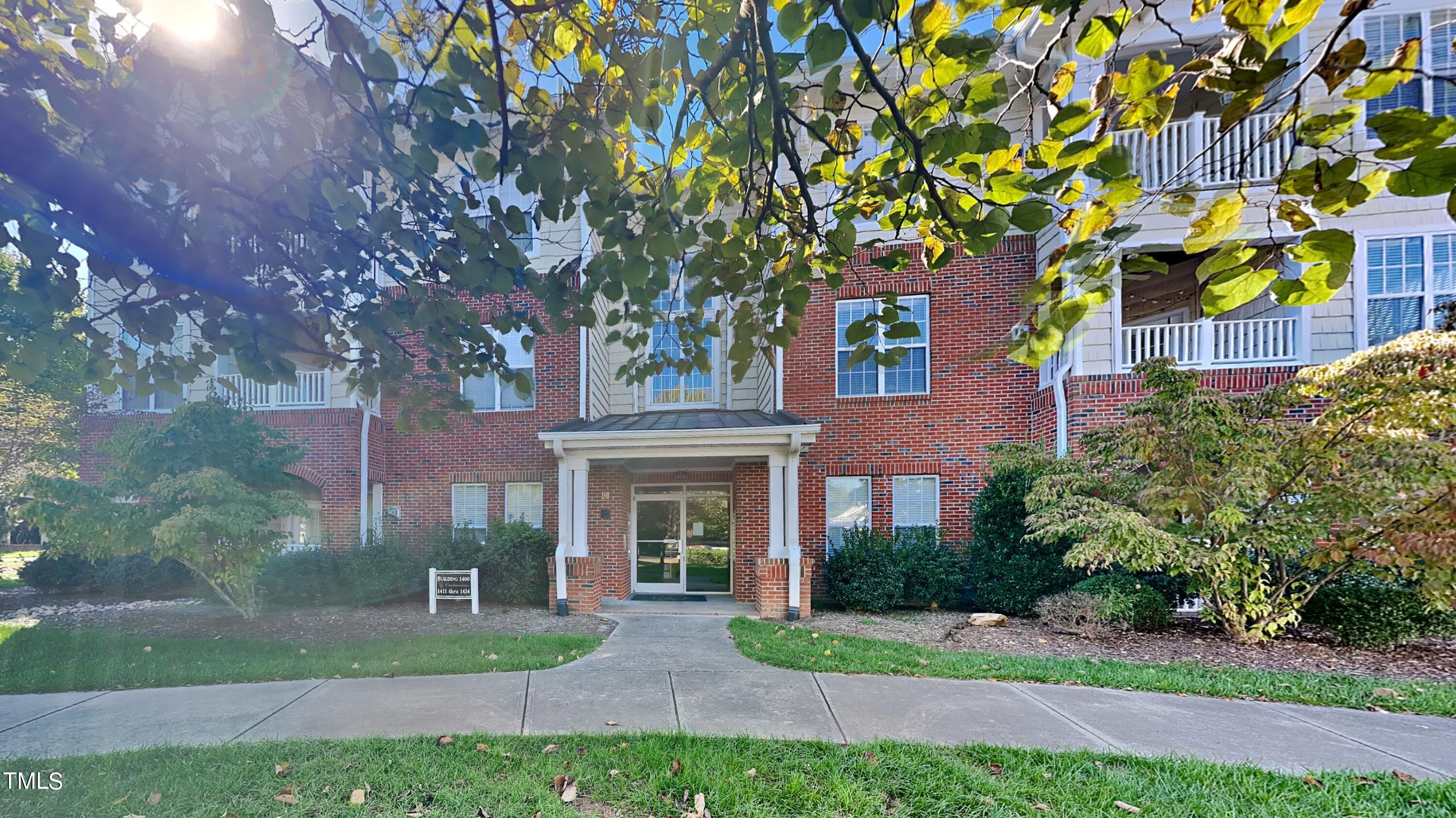 front view of house with a yard and potted plants