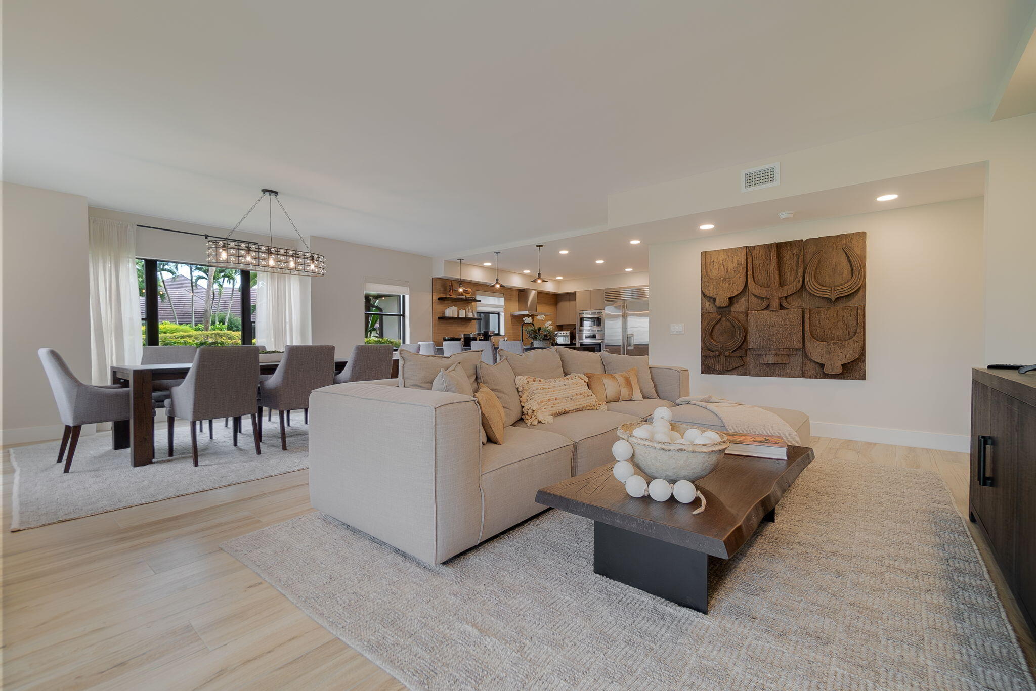 a living room with furniture and a dining table with kitchen view