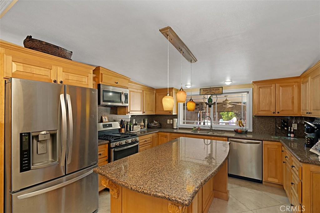 a kitchen with stainless steel appliances granite countertop a sink a stove and refrigerator