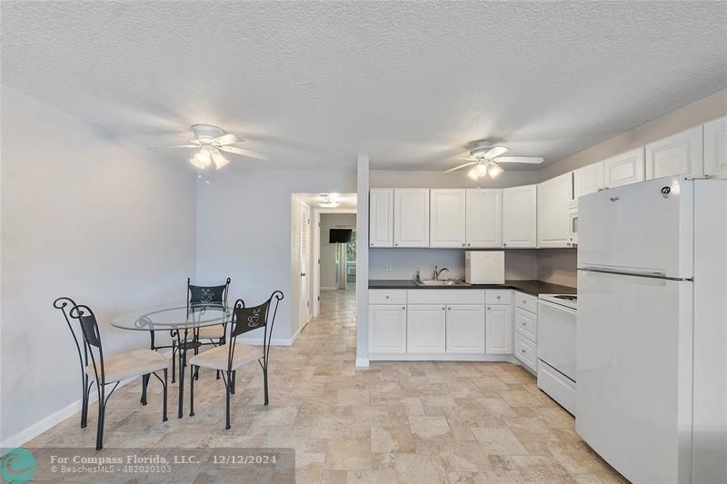 a kitchen with kitchen island a table and chairs in it