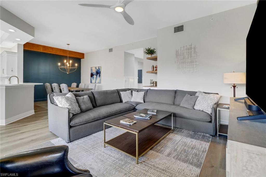 a living room with furniture a flat screen tv and a window