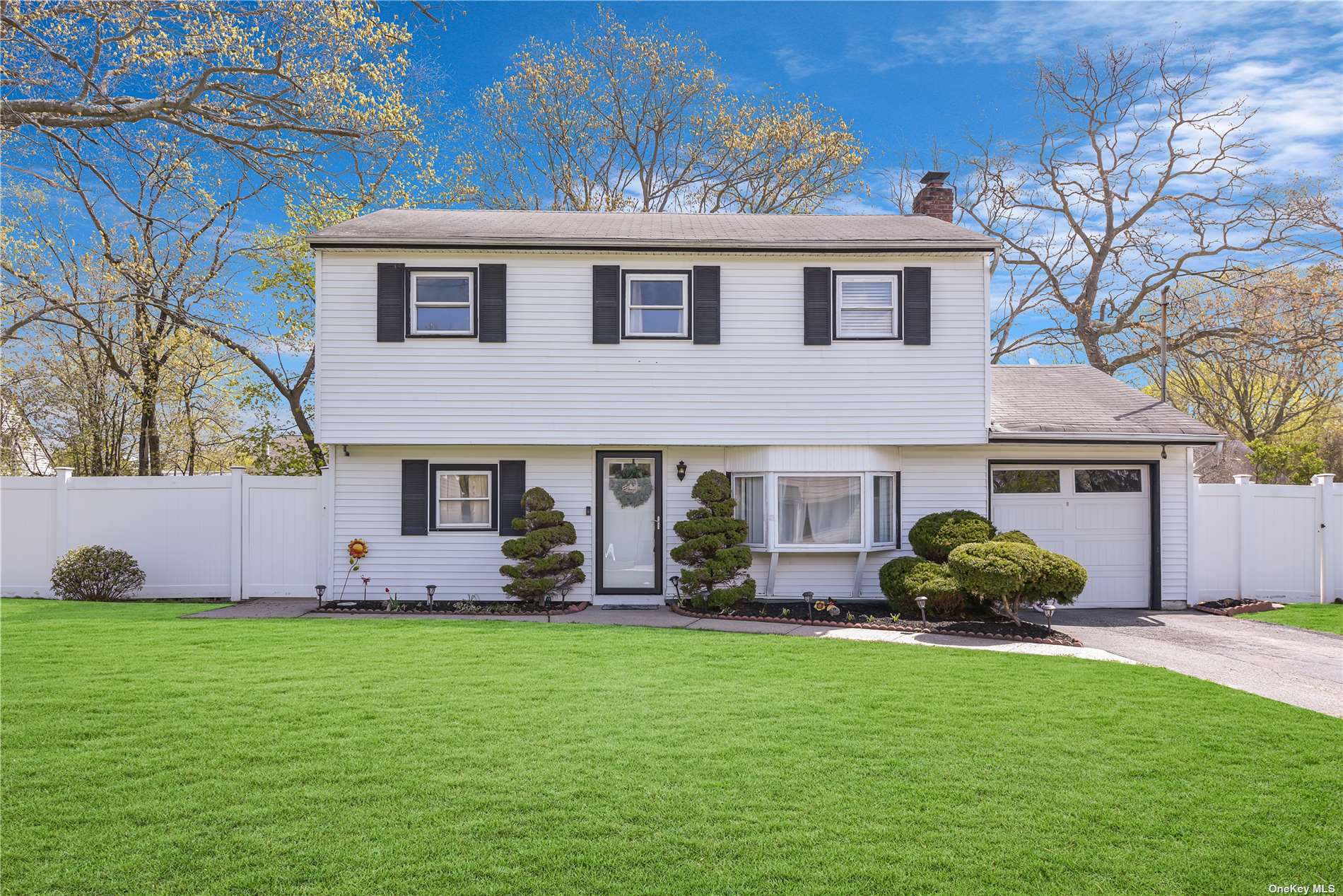 a front view of a house with a garden and yard