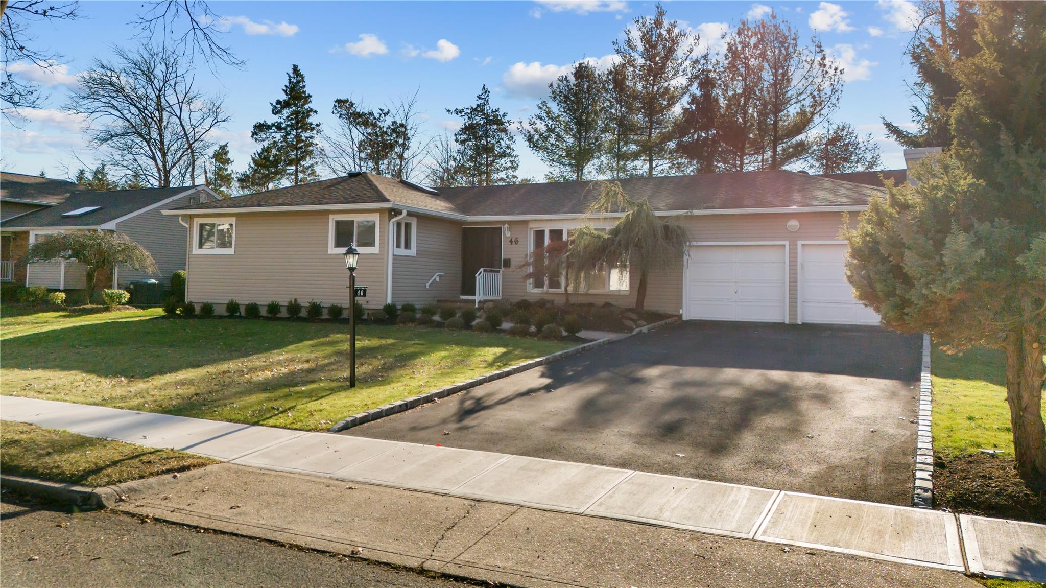 Ranch-style house with a front yard and 2 car garage