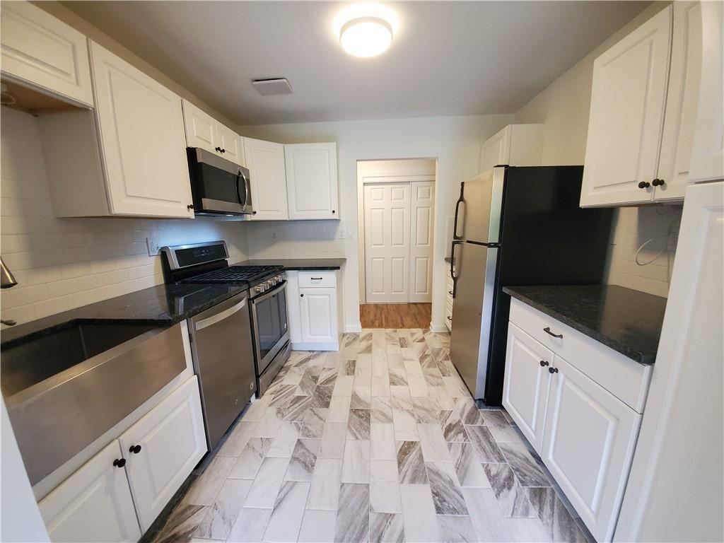 a kitchen with stainless steel appliances a refrigerator sink and microwave