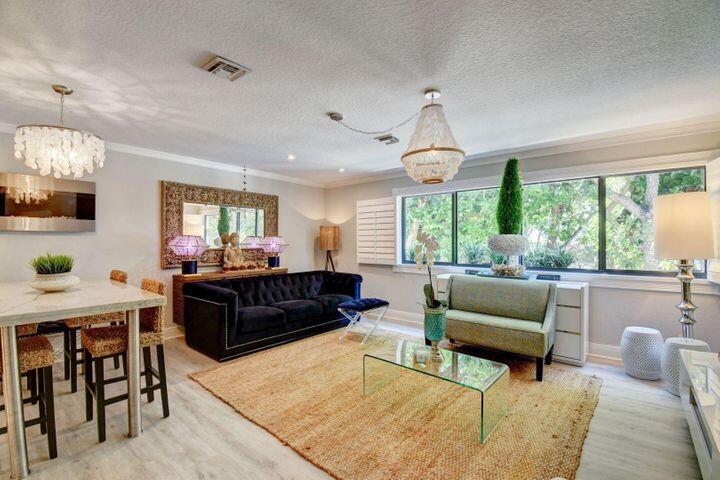 a living room with furniture a large window and a dining table